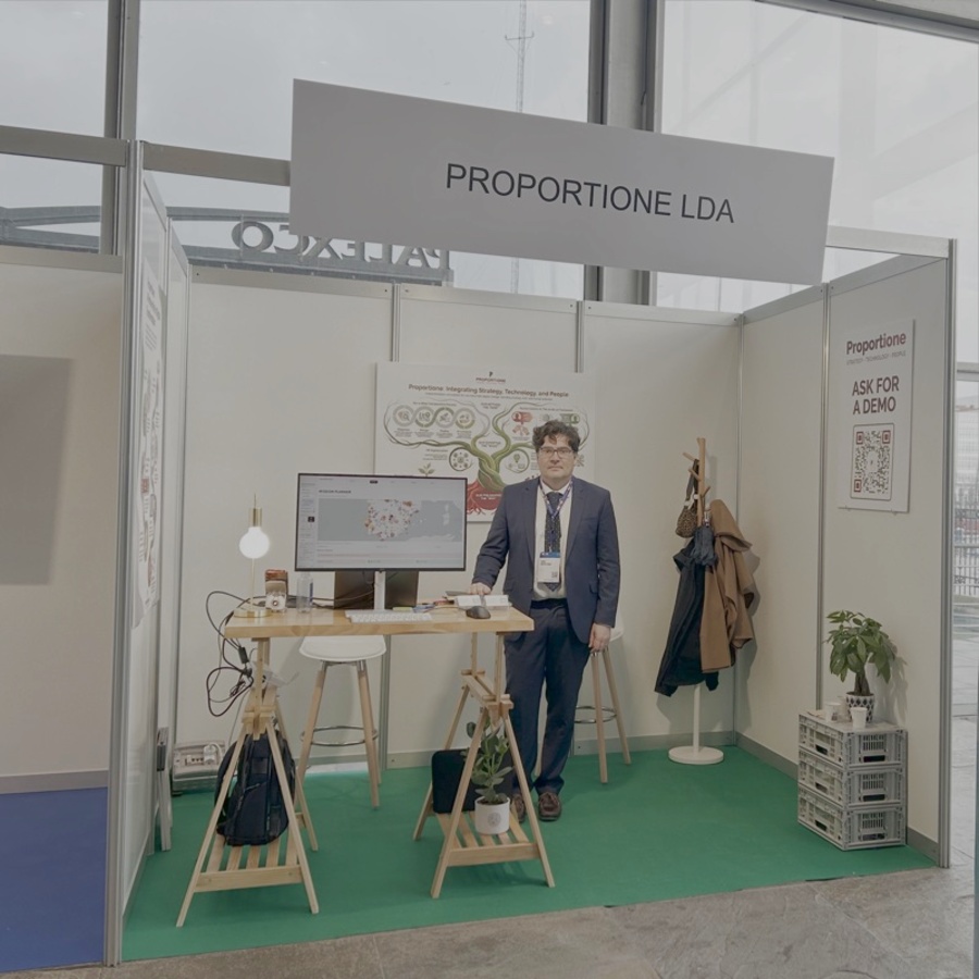 Javier Cuervo no stand da Proportione em Aveiro, com o cartaz «Integrating Strategy, Technology and People».